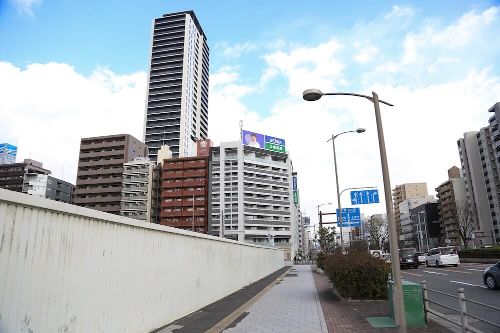 「西長堀」駅からジオタワー新町を見上げた写真